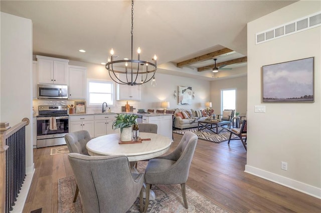 dining space featuring baseboards, visible vents, wood finished floors, beamed ceiling, and recessed lighting