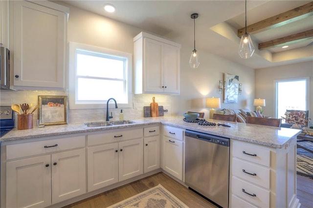 kitchen featuring dishwasher, light wood-style flooring, open floor plan, a peninsula, and a sink