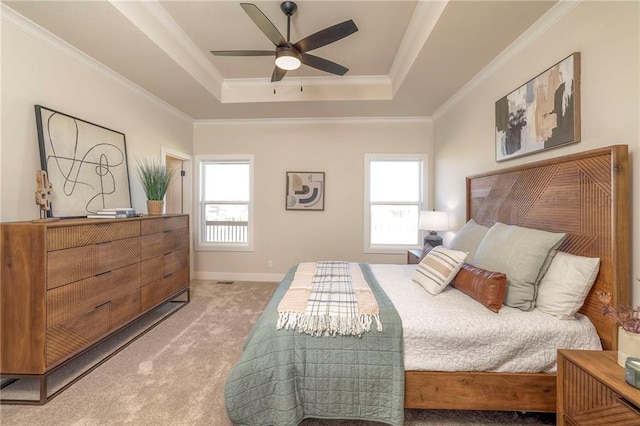 bedroom with a tray ceiling, multiple windows, crown molding, and light carpet