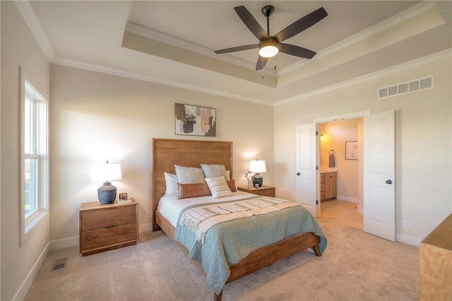 bedroom with a tray ceiling, multiple windows, and visible vents