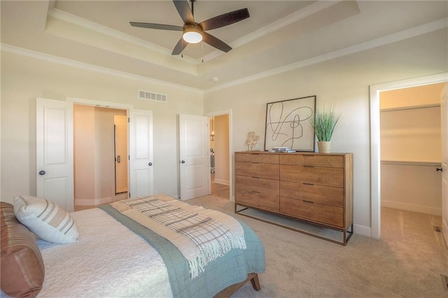 bedroom with ornamental molding, a raised ceiling, visible vents, and light carpet