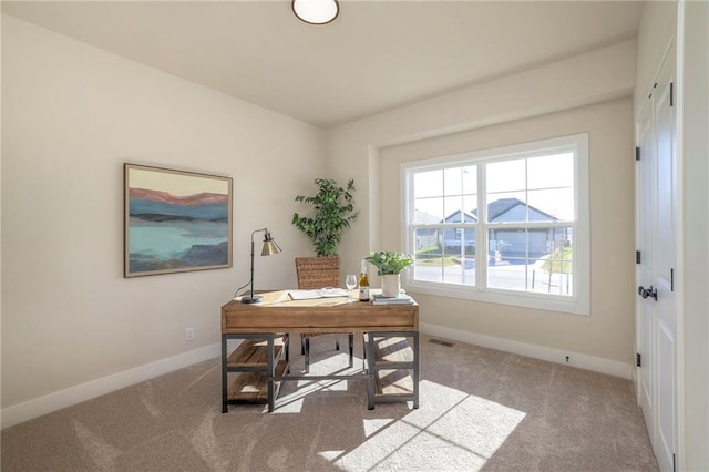 carpeted office featuring visible vents and baseboards