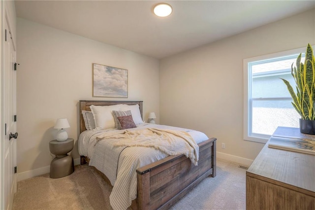 bedroom with light carpet and baseboards