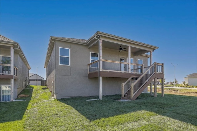 back of property with stucco siding, a lawn, central AC unit, a ceiling fan, and stairs