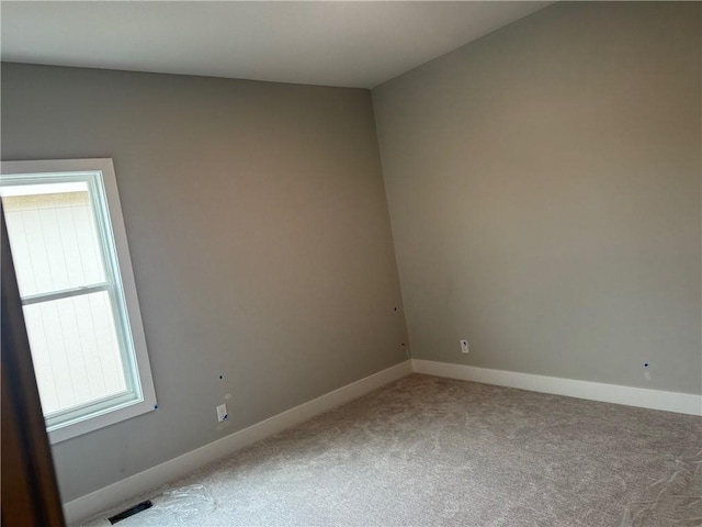 unfurnished room with carpet and baseboards