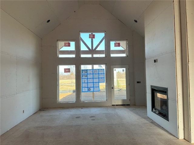 unfurnished living room featuring high vaulted ceiling