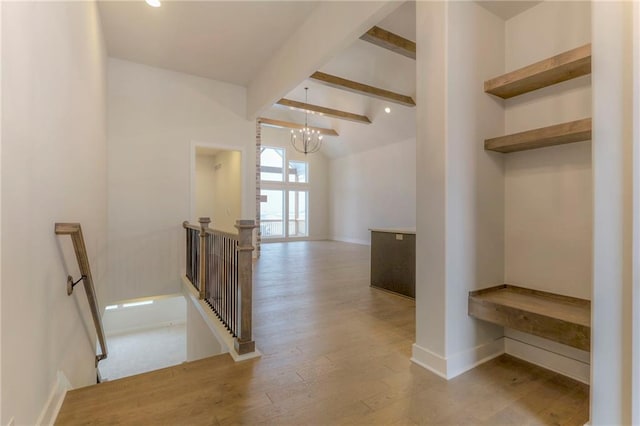 corridor featuring vaulted ceiling with beams, a chandelier, and light wood-type flooring