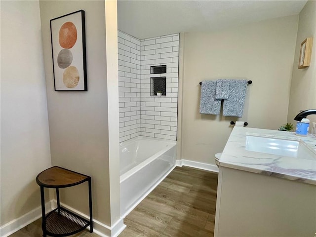 bathroom featuring tiled shower / bath combo, hardwood / wood-style flooring, and vanity