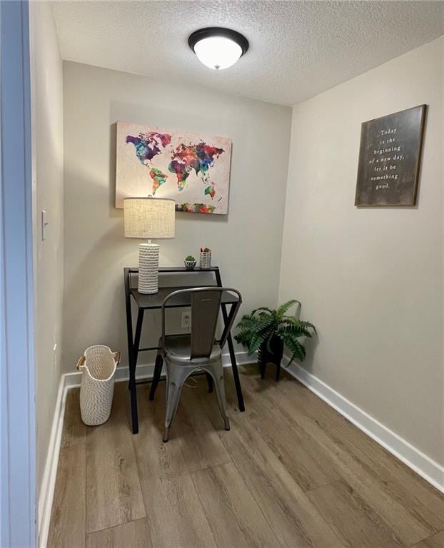 office with hardwood / wood-style flooring and a textured ceiling