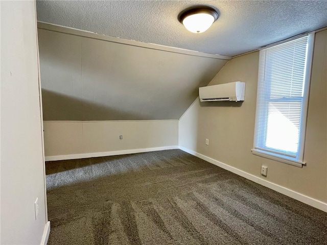 bonus room with a textured ceiling, carpet flooring, a wall mounted AC, and vaulted ceiling