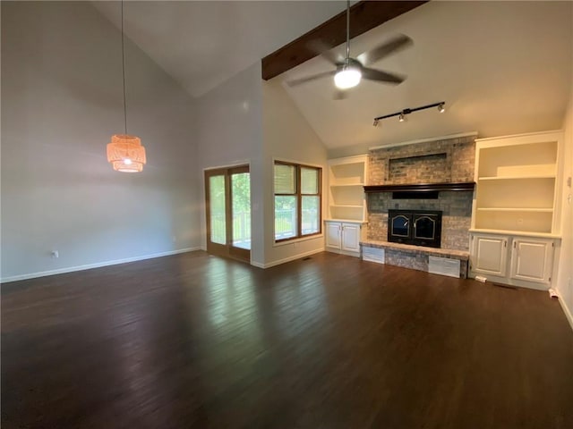 unfurnished living room featuring beam ceiling, ceiling fan, dark wood-type flooring, high vaulted ceiling, and a fireplace