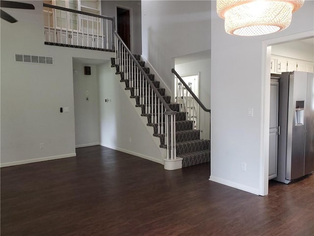 interior space featuring hardwood / wood-style flooring, a towering ceiling, and an inviting chandelier