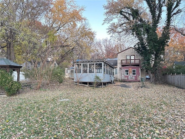 rear view of house featuring a sunroom and a balcony