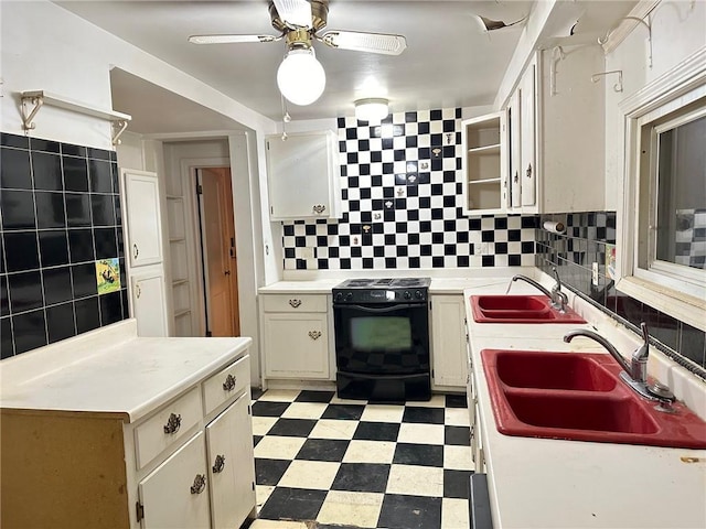 kitchen with backsplash, black / electric stove, and sink