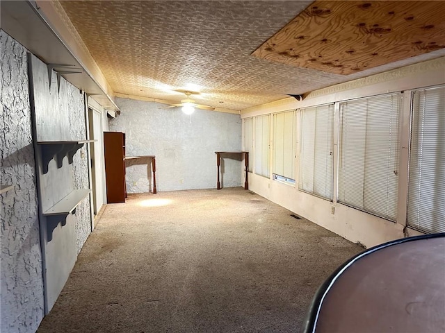 basement with ceiling fan and carpet