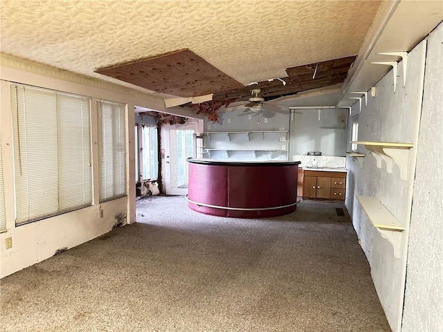 kitchen featuring kitchen peninsula, ceiling fan, and carpet floors