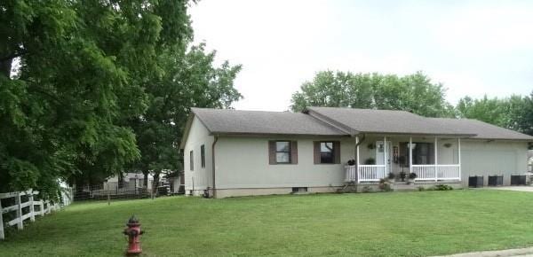 view of front of house with covered porch and a front lawn