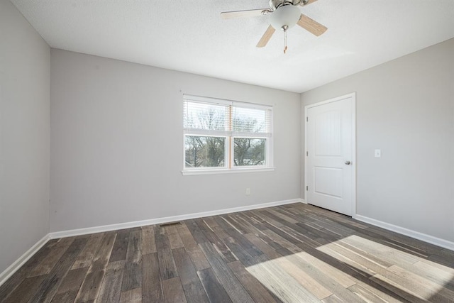 unfurnished room featuring ceiling fan and dark wood-type flooring