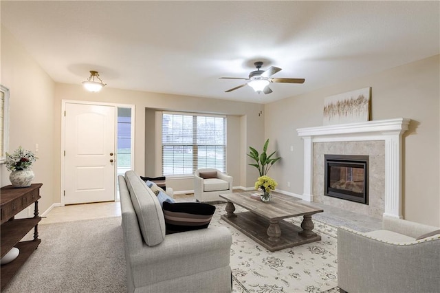 carpeted living room featuring ceiling fan and a tiled fireplace