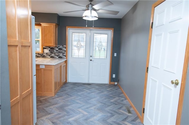 doorway to outside with dark parquet floors, ceiling fan, and a healthy amount of sunlight