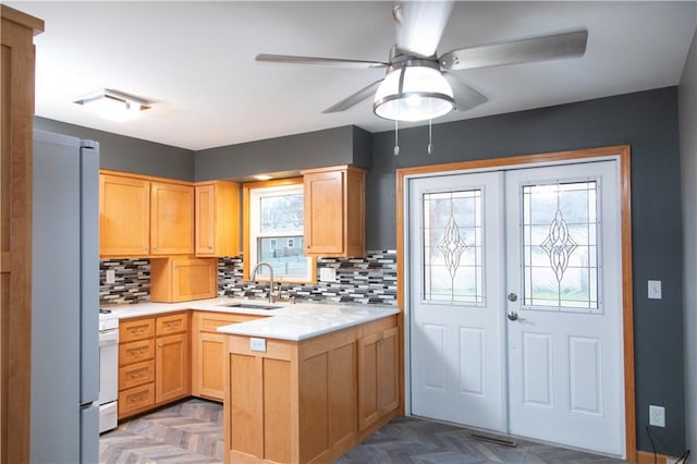 kitchen with backsplash, white appliances, dark parquet floors, ceiling fan, and sink