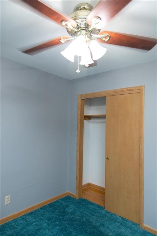 unfurnished bedroom with ceiling fan, dark carpet, and a closet