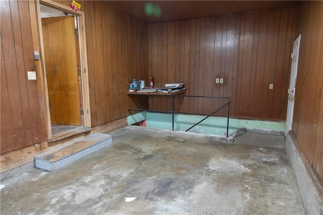 miscellaneous room with concrete floors and wood walls