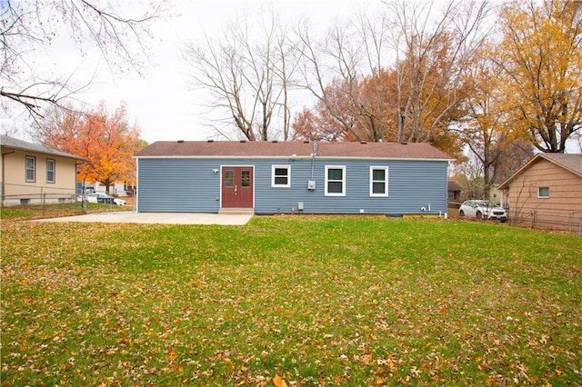 back of property with a yard and a patio area