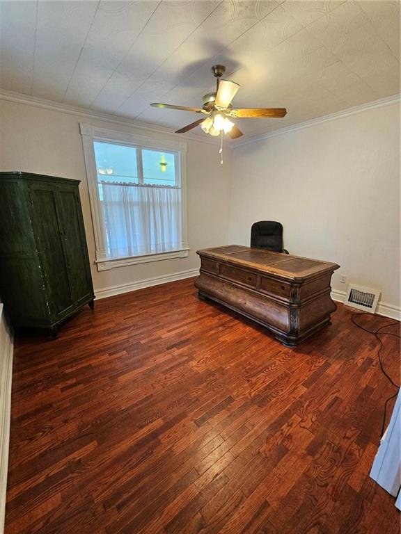 bedroom with ceiling fan, dark hardwood / wood-style floors, and ornamental molding