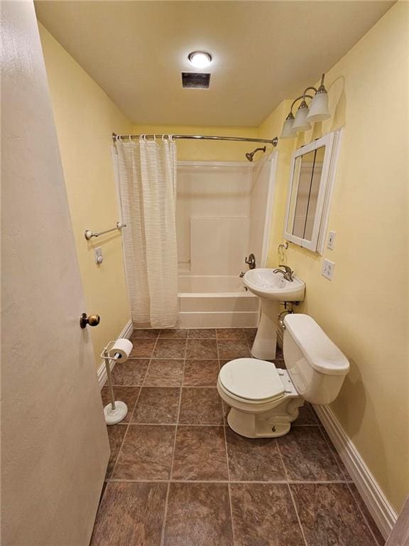 bathroom featuring toilet and shower / tub combo with curtain