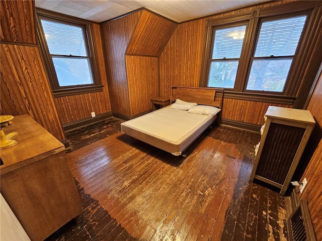 bedroom with dark wood-type flooring and wood walls