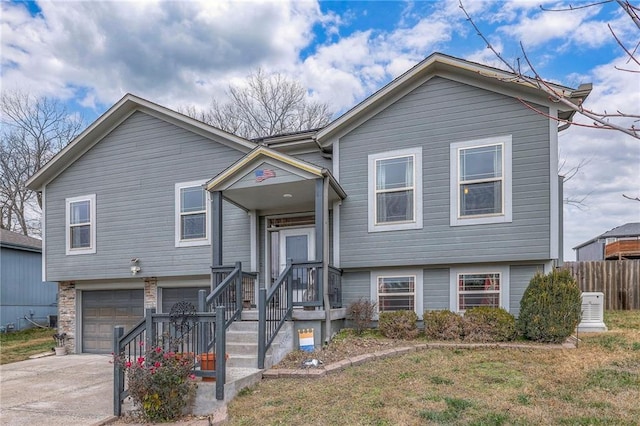 raised ranch featuring central AC unit and a garage