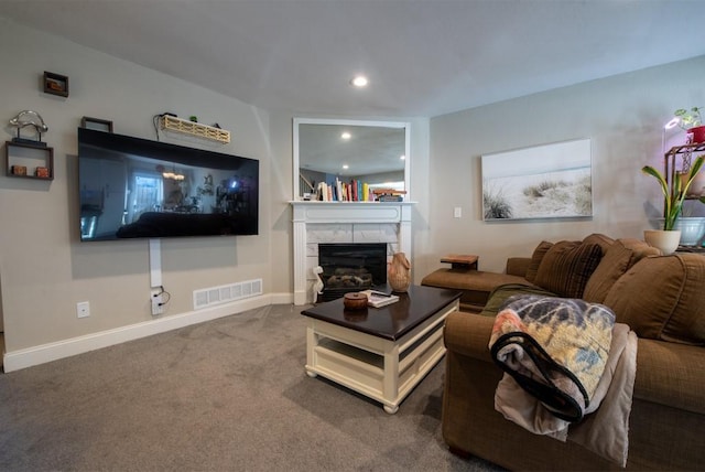 living room with a tile fireplace and carpet floors