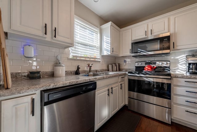 kitchen with white cabinets, appliances with stainless steel finishes, decorative backsplash, and sink