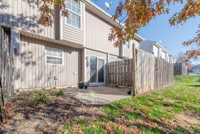 rear view of property with a patio and a lawn