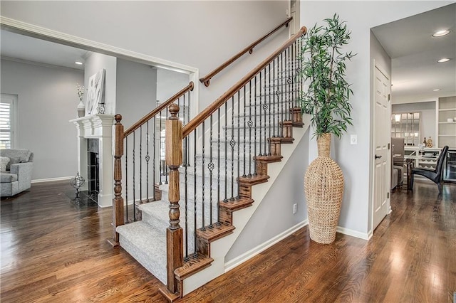 stairway with hardwood / wood-style flooring and crown molding