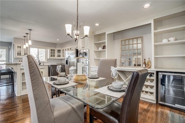 dining space featuring built in shelves, dark hardwood / wood-style flooring, wine cooler, and a chandelier