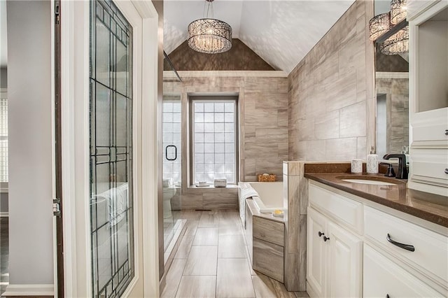 bathroom featuring vanity, vaulted ceiling, separate shower and tub, tile walls, and a chandelier