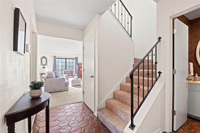 stairway featuring a textured ceiling