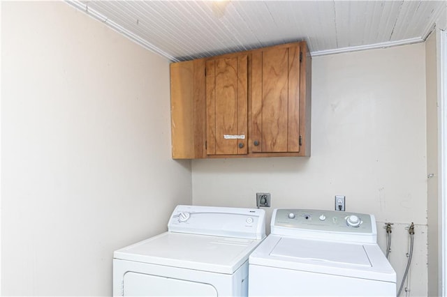 laundry room with washing machine and dryer, cabinets, and ornamental molding