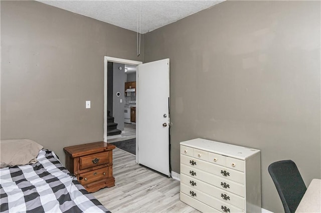 bedroom featuring light wood-type flooring and a textured ceiling