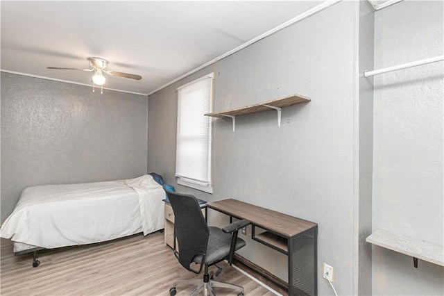 bedroom featuring light hardwood / wood-style flooring, ceiling fan, and crown molding