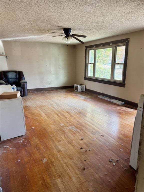 unfurnished living room with ceiling fan, a textured ceiling, and hardwood / wood-style flooring