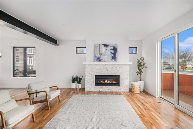 living area with beamed ceiling and hardwood / wood-style floors