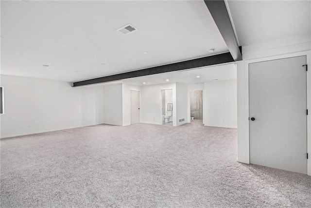 interior space featuring beam ceiling and light colored carpet