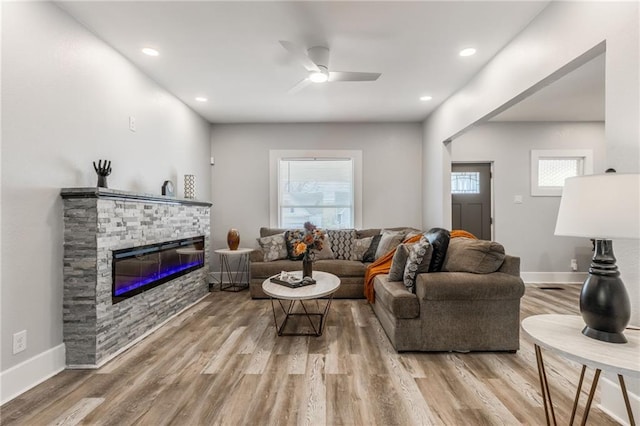 living room featuring a fireplace, hardwood / wood-style flooring, and ceiling fan