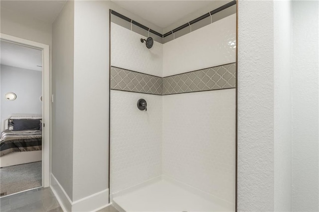 bathroom with a tile shower and tile patterned floors