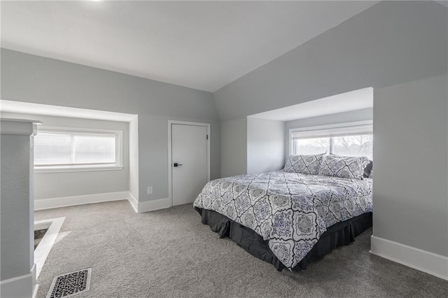 carpeted bedroom featuring multiple windows and lofted ceiling