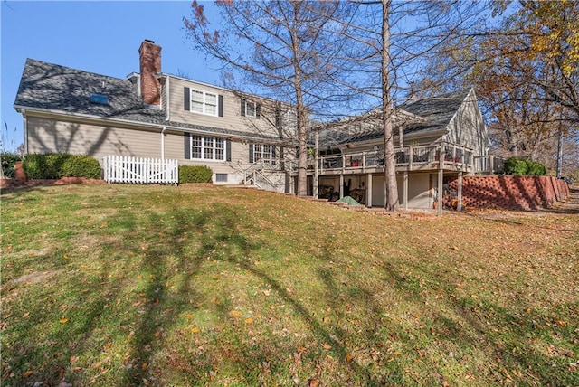 back of property with a wooden deck and a yard