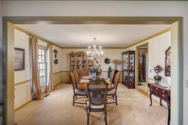 401 Taylor Rd, Independence, KS 67301 - dining area with crown molding, a chandelier, light carpet, a decorative wall, and a wainscoted wall